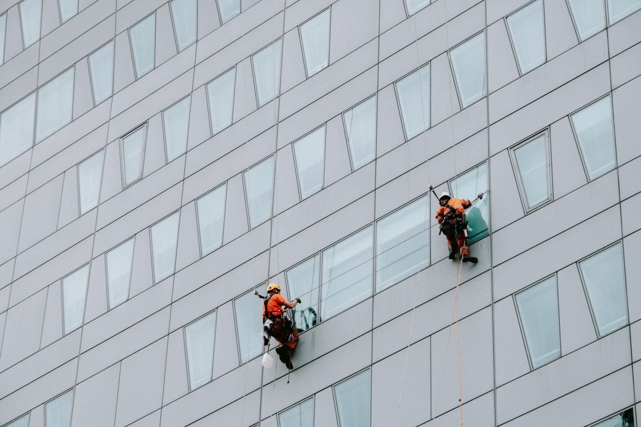 services-01 Skyscraper window cleaners in safety equipment washing the building’s facade.