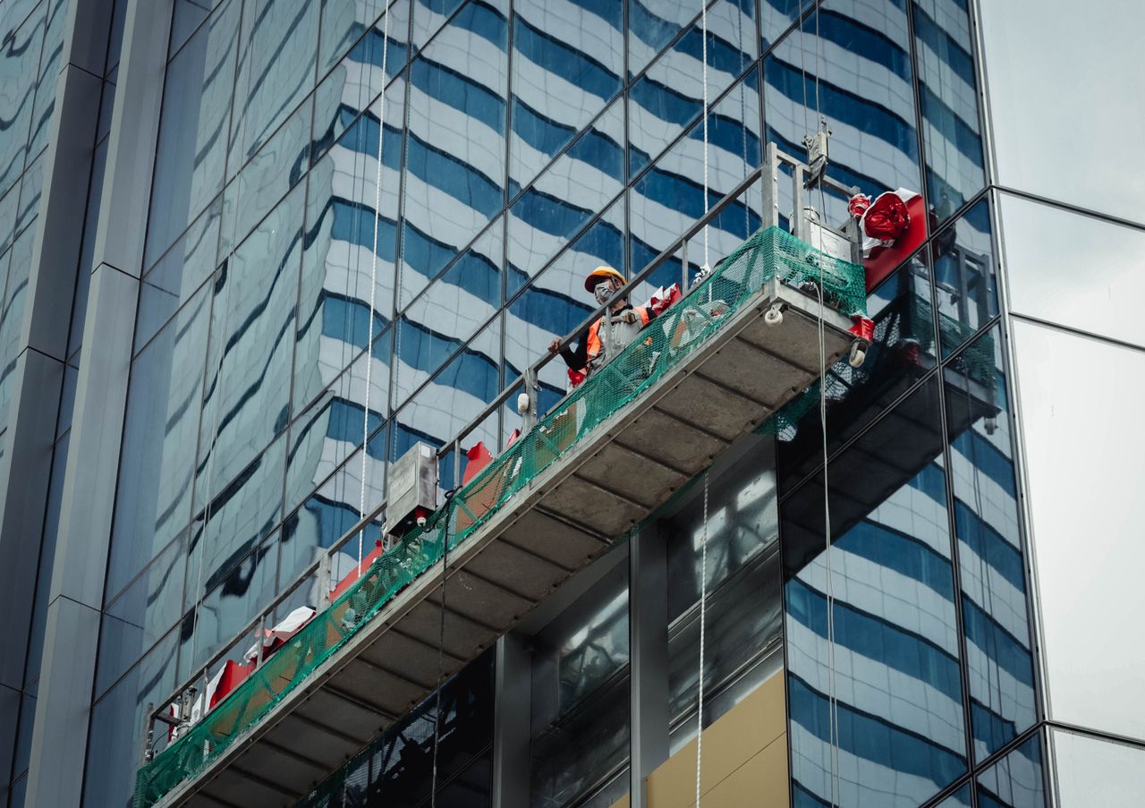 services-04 Urban worker washing windows on a high-rise in Ho Chi Minh City, Vietnam.